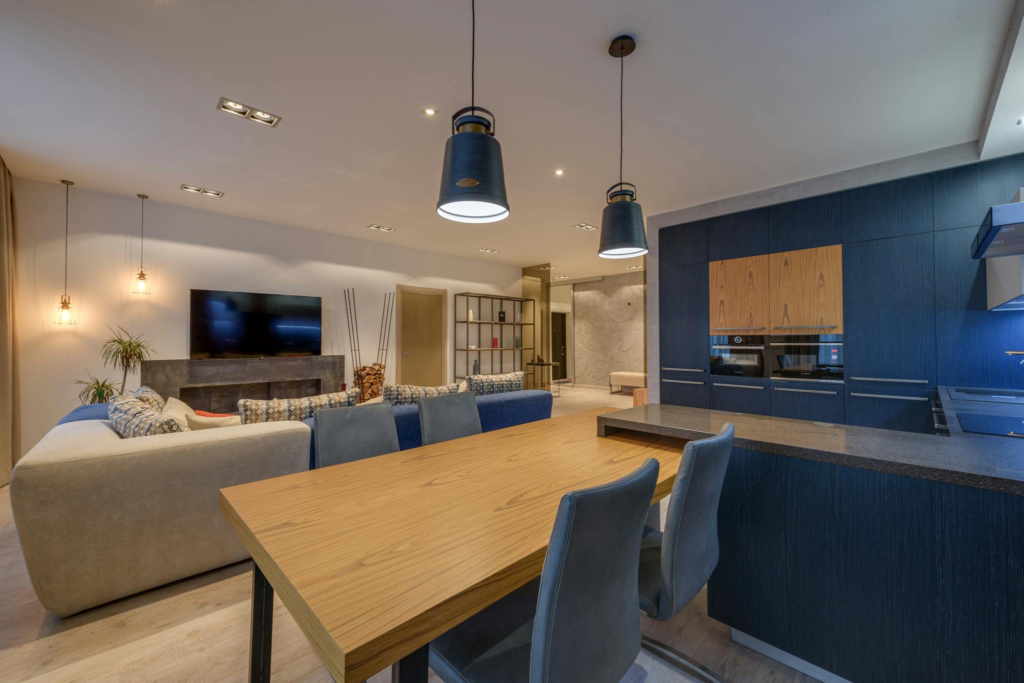 Interior of modern lounge with kitchen illuminated with lamps in comfortable spacious apartment